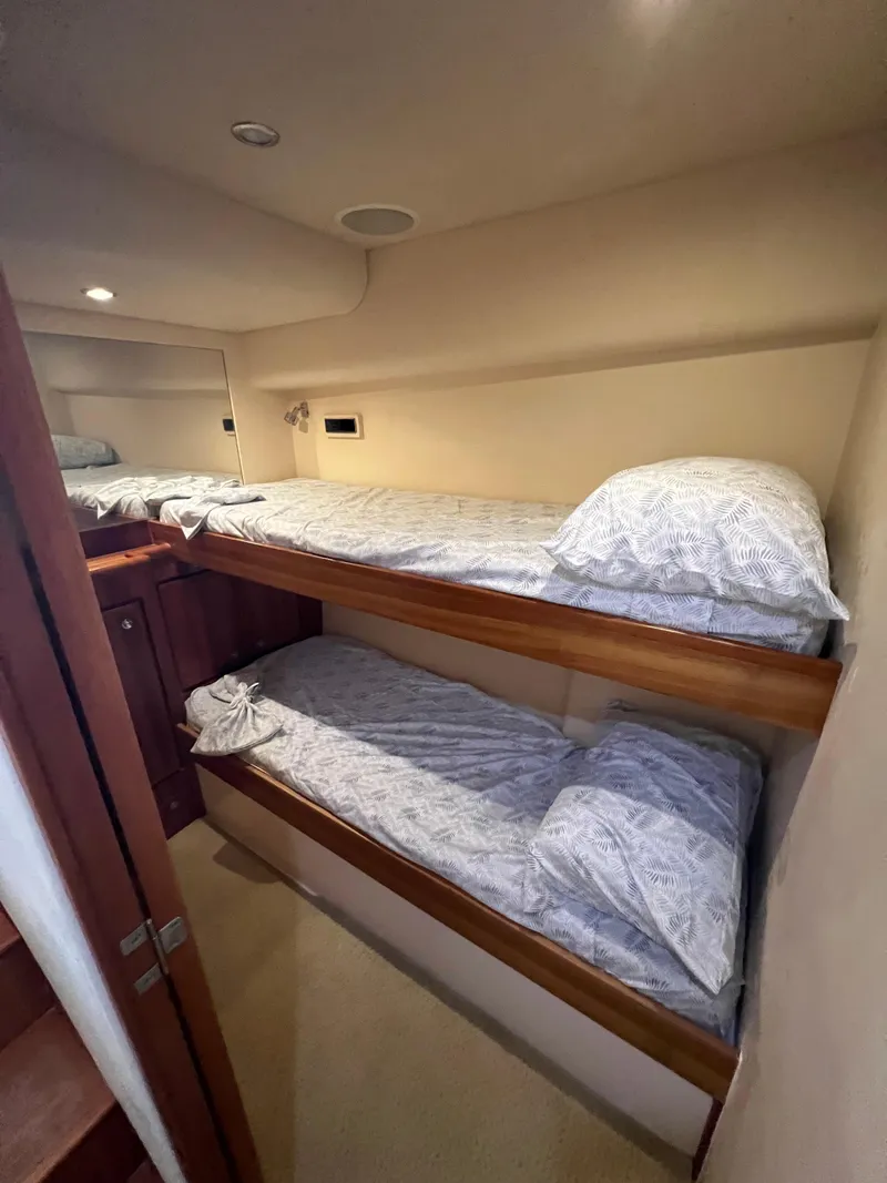 Slide: The Image of 2009 Bertram 45 Convertible yacht cabin with bunk beds and cozy bedding. - 18