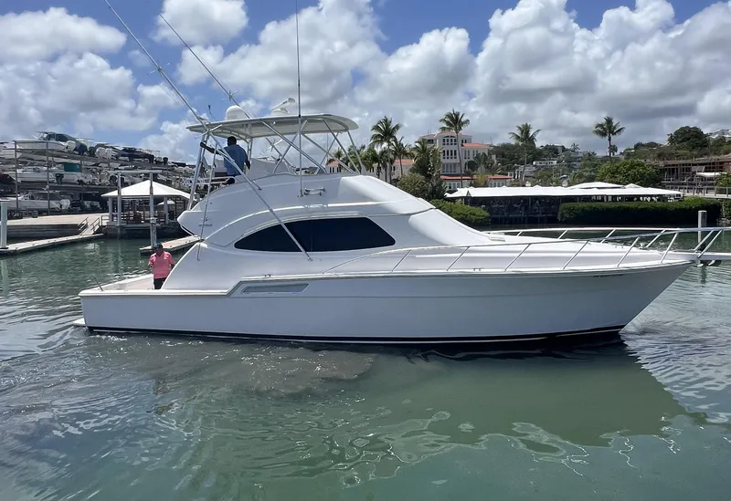 Slide: The Image of 2009 Bertram 45 Convertible yacht docked in a marina under a partly cloudy sky. - 2
