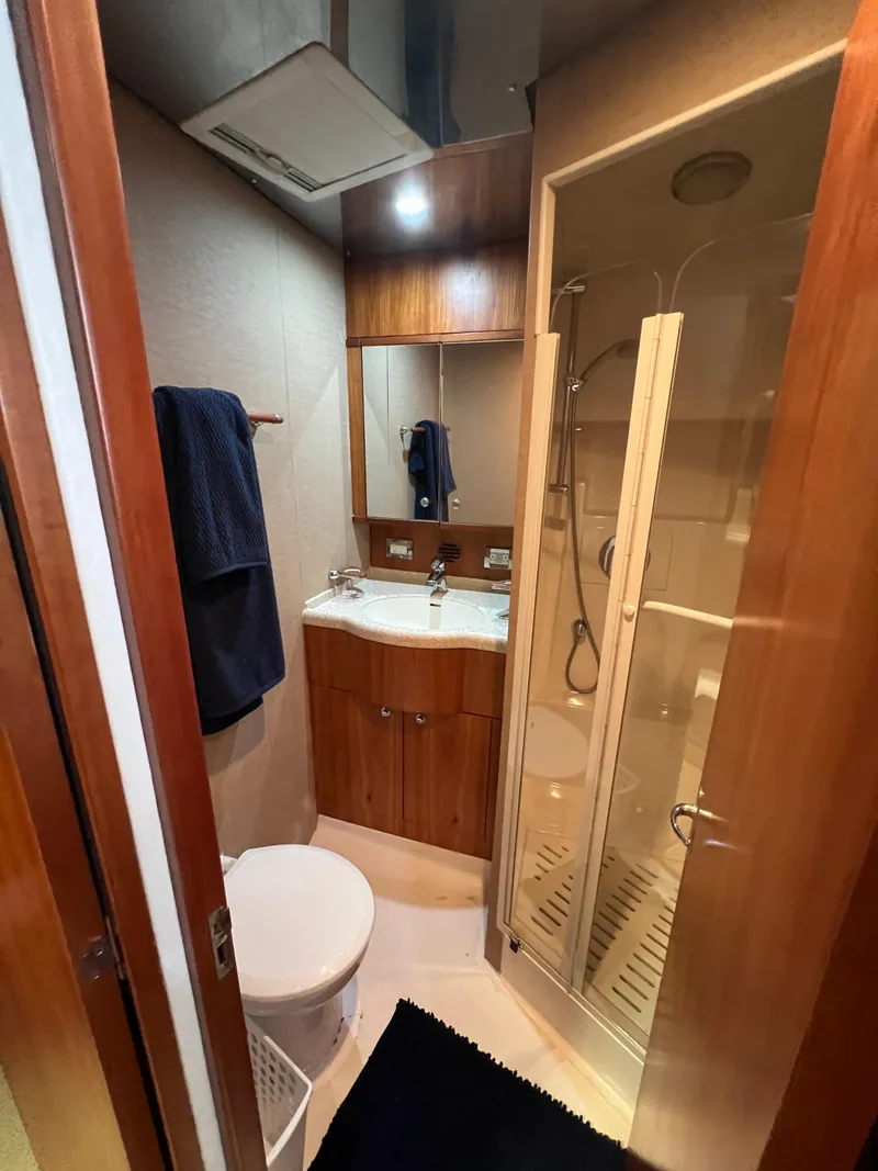 Slide: The Image of 2009 Bertram 45 Convertible yacht bathroom with shower, sink, and wooden cabinetry. - 23
