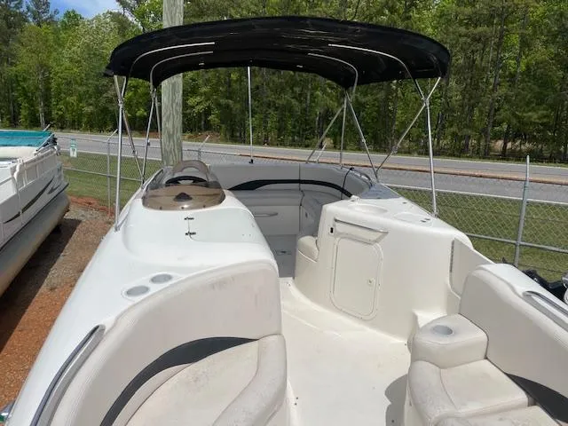 Slide: The Image of 2000 Chaparral Sunesta 232 boat with canopy, parked near a road and trees. - 14