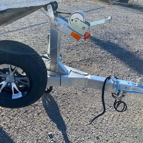 Slide: The Image of 2024 Xpress XP180 boat trailer hitch and wheel on gravel surface. - 4