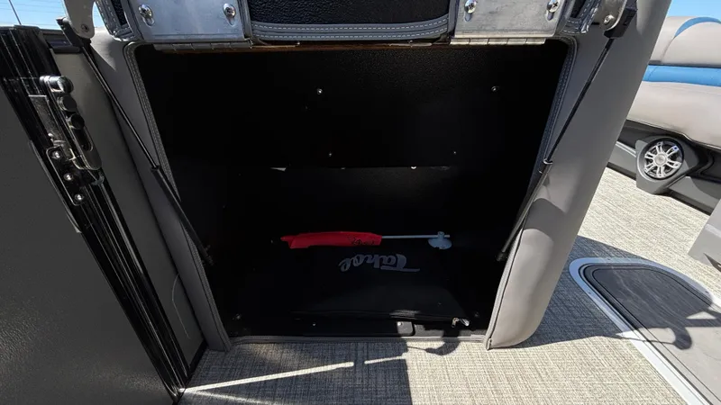 Slide: The Image of 2024 Tahoe Pontoon 2585 Cascade storage compartment with open door, revealing interior space. - 26