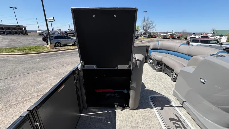 Slide: The Image of 2024 Tahoe Pontoon 2585 Cascade interior with open storage compartment and seating area. - 27