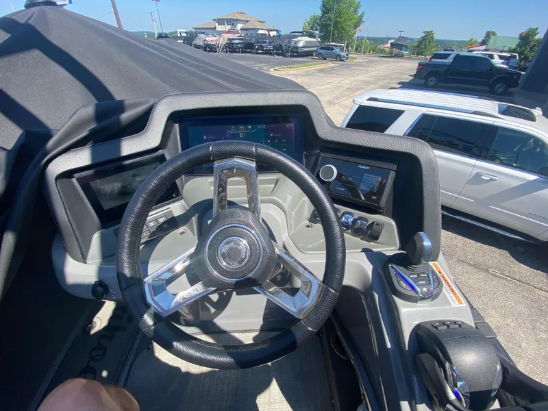 Slide: The Image of 2024 Tahoe 2585 Cascade boat dashboard with steering wheel and control panels. - 31