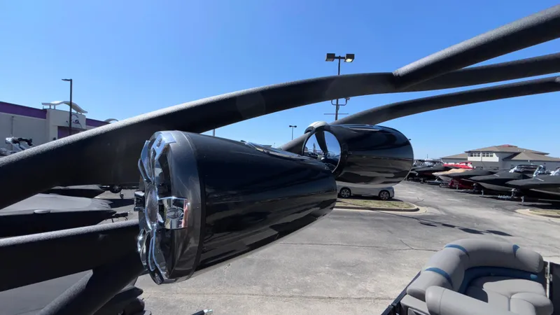 Slide: The Image of 2024 Tahoe Pontoon 2585 Cascade speakers on display at a dealership under clear blue sky. - 44