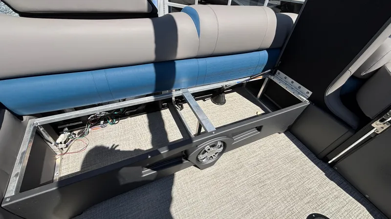 Slide: The Image of 2024 Tahoe Pontoon 2585 Cascade interior storage compartment with blue and gray seating. - 7