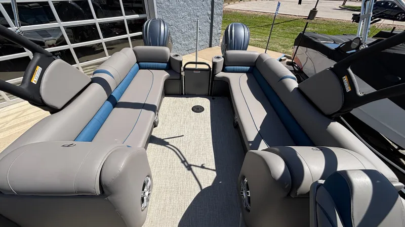 Slide: The Image of 2024 Tahoe Pontoon 2585 Cascade interior with gray and blue seating, outdoor setting. - 8