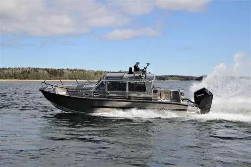 Slide: The Image of 2025 Alukin WA 950 boat cruising on a lake with forested shoreline. - 1