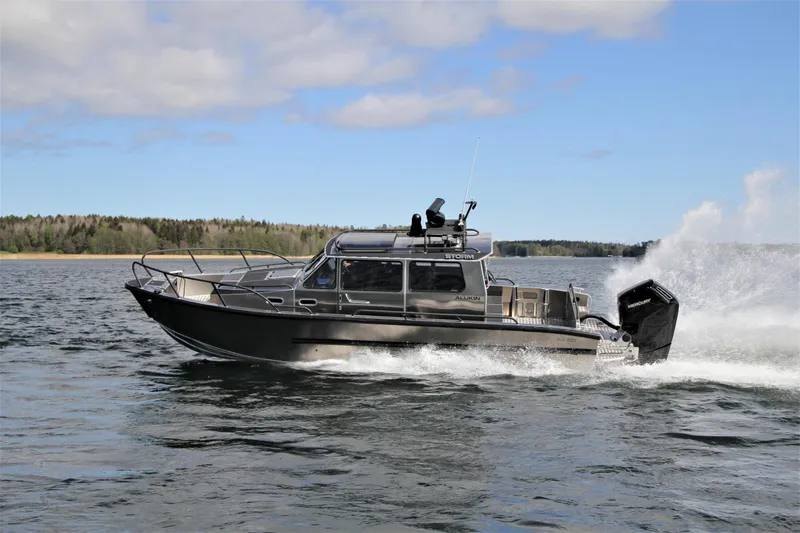 Slide: The Image of 2025 Alukin WA 950 boat cruising on a lake with forested shoreline. - 10