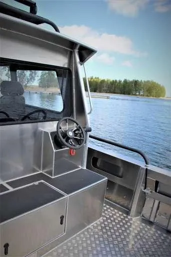 Slide: The Image of 2025 Alukin WA 950 boat interior with steering wheel, overlooking serene lake and trees. - 6