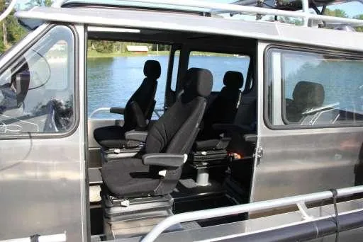 Slide: The Image of Interior view of 2025 Alukin WA 950 boat with black seats by the water. - 9