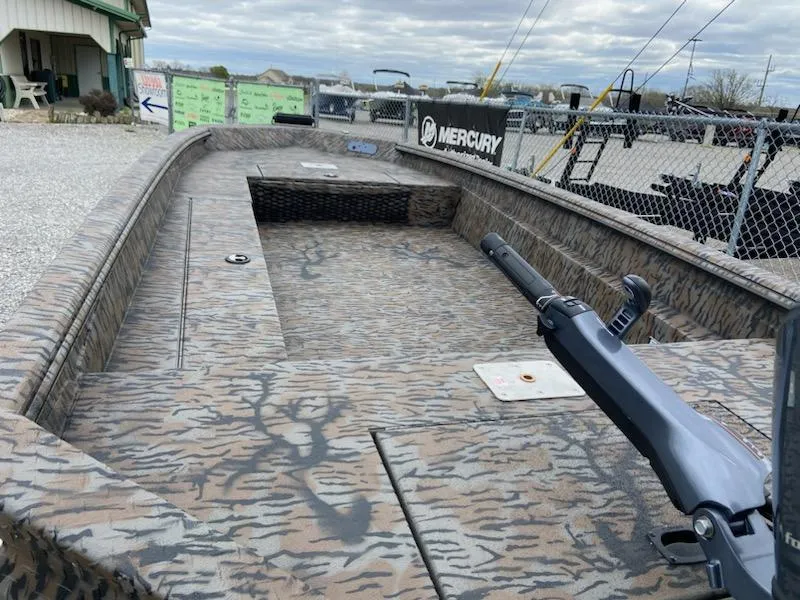 Slide: The Image of 2024 Express H16DB boat with camouflage design, docked near a Mercury sign. - 3