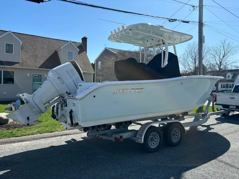 Slide: The Image of 2022 Sea Pro 239 Center Console boat on trailer, parked in residential area. - 2