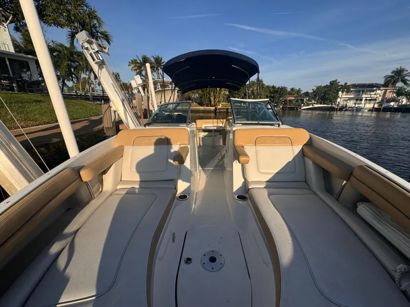 Slide: The Image of 2011 Sea Ray 280 Sundeck boat interior with seating, docked by a scenic waterfront. - 10