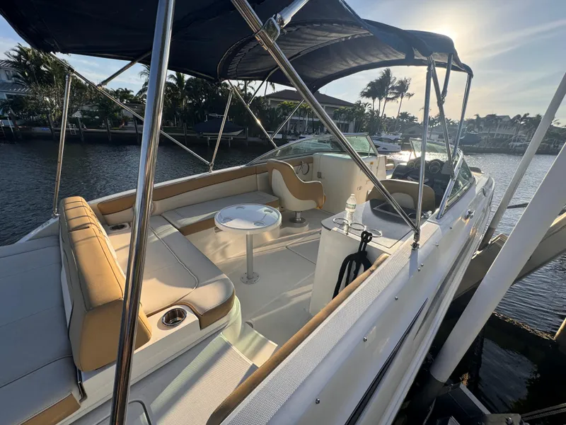 Slide: The Image of 2011 Sea Ray 280 Sundeck boat with spacious seating and canopy, docked by the water. - 4