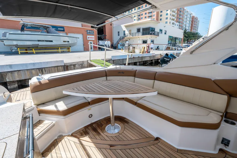 Slide: The Image of 2015 Sea Ray 350 SLX yacht with elegant seating and table, docked at a marina. - 15