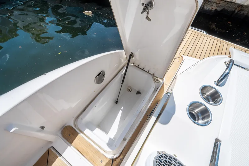 Slide: The Image of 2015 Sea Ray 350 SLX boat storage compartment open by water. - 17