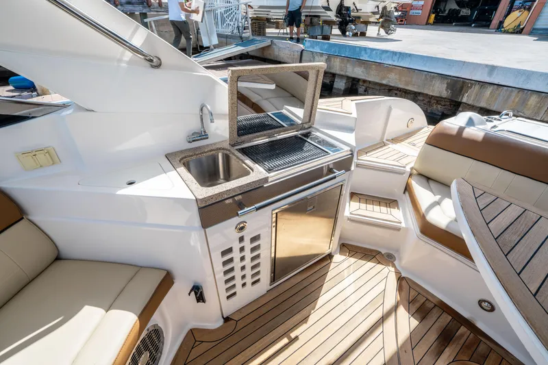 Slide: The Image of 2015 Sea Ray 350 SLX boat interior with kitchenette, sink, and seating area. - 21