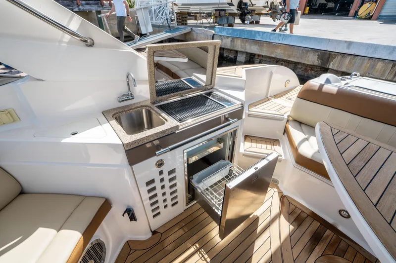 Slide: The Image of 2015 Sea Ray 350 SLX boat interior with kitchenette and seating area. - 22