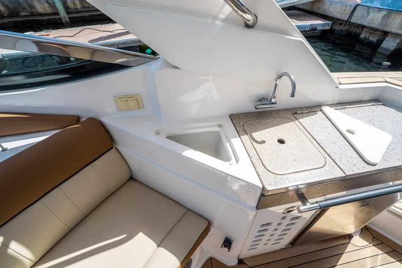 Slide: The Image of 2015 Sea Ray 350 SLX boat interior with sink and seating area. - 25