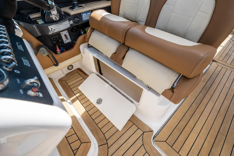 Slide: The Image of 2015 Sea Ray 350 SLX boat interior with tan and white seating, wooden flooring, and control panel. - 33