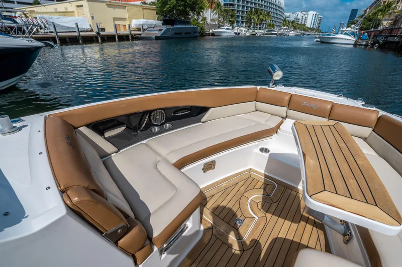 Slide: The Image of 2015 Sea Ray 350 SLX boat with luxurious seating and wooden deck, docked in a marina. - 42