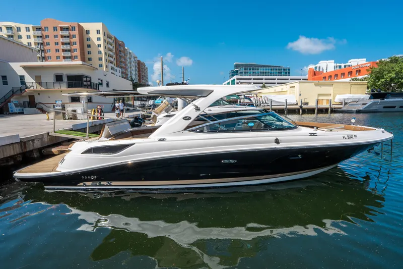 Slide: The Image of 2015 Sea Ray 350 SLX boat docked in a marina with urban buildings in the background. - 5