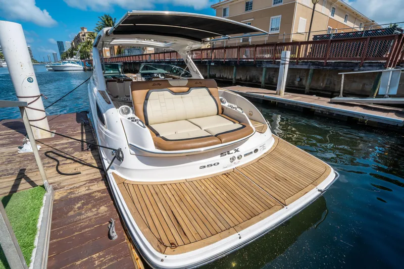 Slide: The Image of 2015 Sea Ray 350 SLX luxury boat docked, featuring spacious seating and sleek design. - 8
