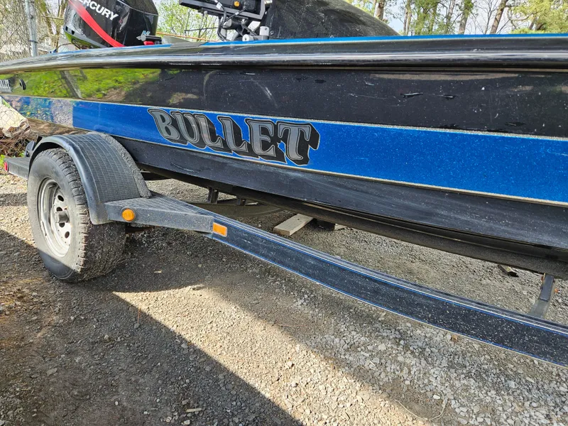 Slide: The Image of 1993 Bullet 20XD boat with blue and black design on a trailer. - 11