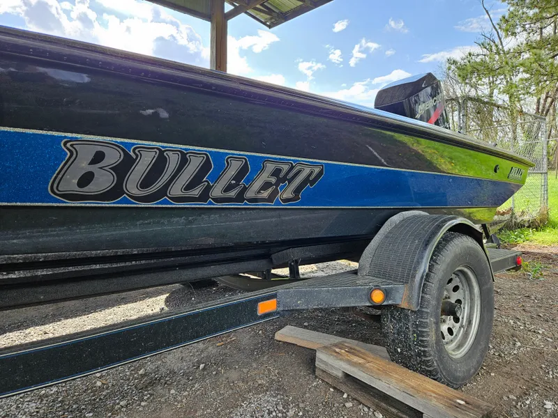 Slide: The Image of 1993 Bullet 20XD boat on trailer, blue and black design, parked outdoors. - 4