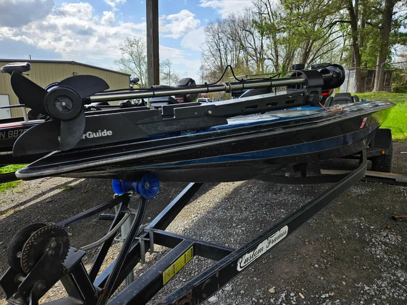 Slide: The Image of 1993 Bullet 20XD boat on trailer, featuring a trolling motor, parked outdoors. - 8