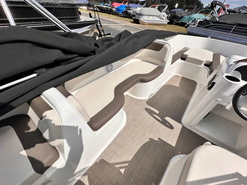 Slide: The Image of 2023 Bayliner Element 18 Deck Boat interior with beige seating and carpeted floor. - 3