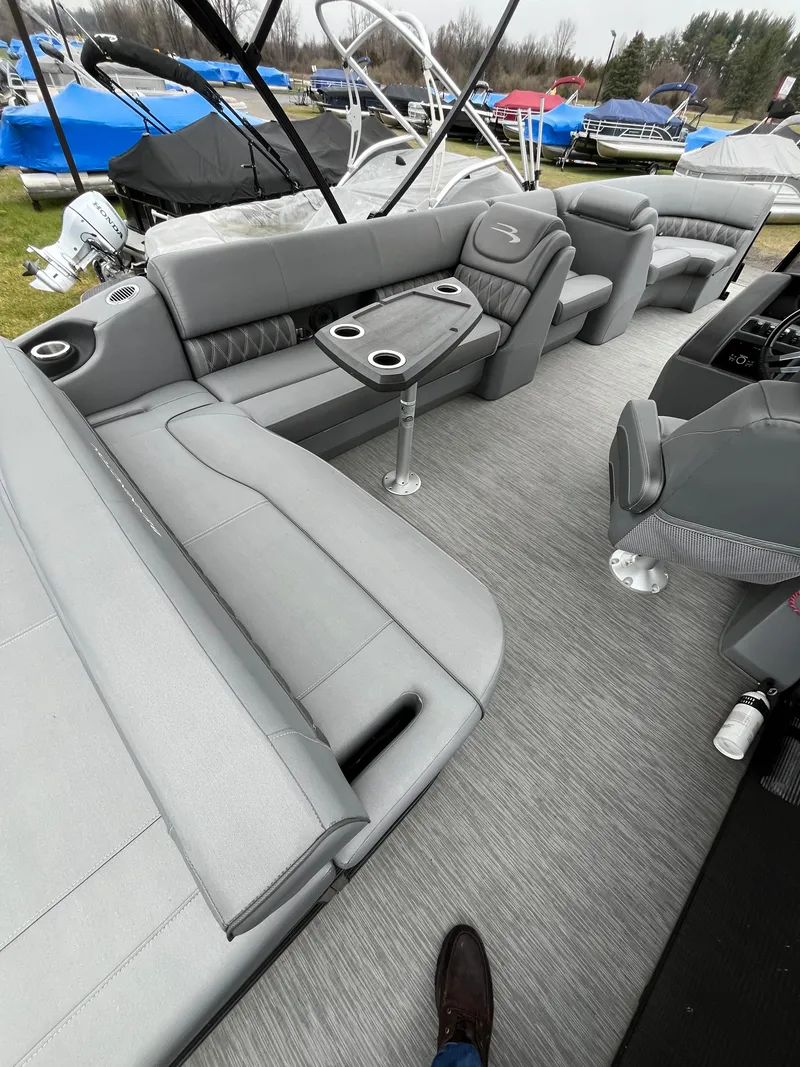 Slide: The Image of 2022 Bennington LXS SPORT 24 LXSB pontoon boat with spacious gray seating and table. - 11