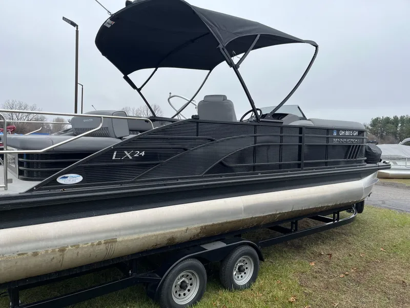 Slide: The Image of 2022 Bennington LXS SPORT 24 LXSB pontoon boat on trailer, black exterior, canopy open. - 3