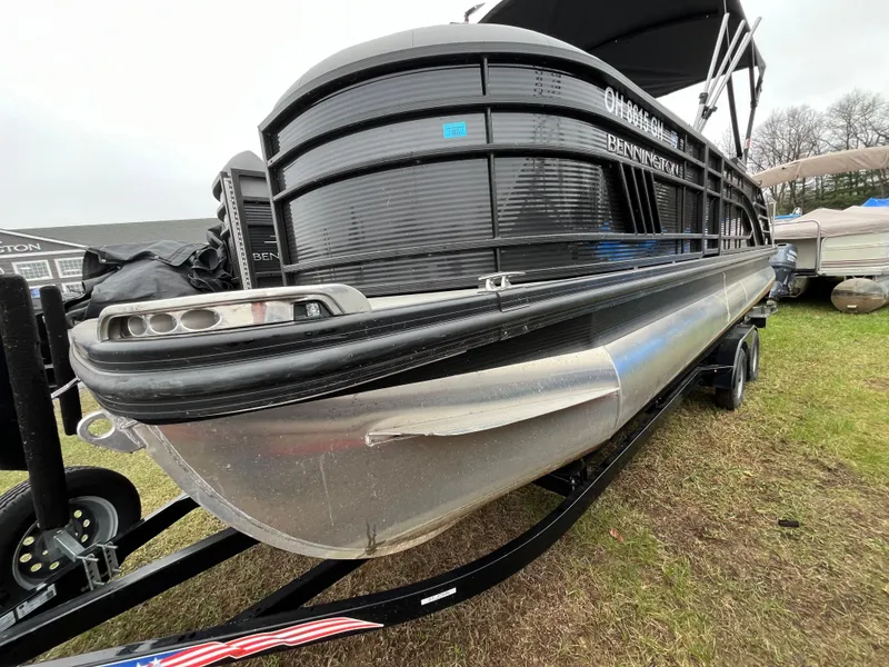 Slide: The Image of 2022 Bennington LXS SPORT 24 LXSB pontoon boat on trailer, displayed outdoors. - 4