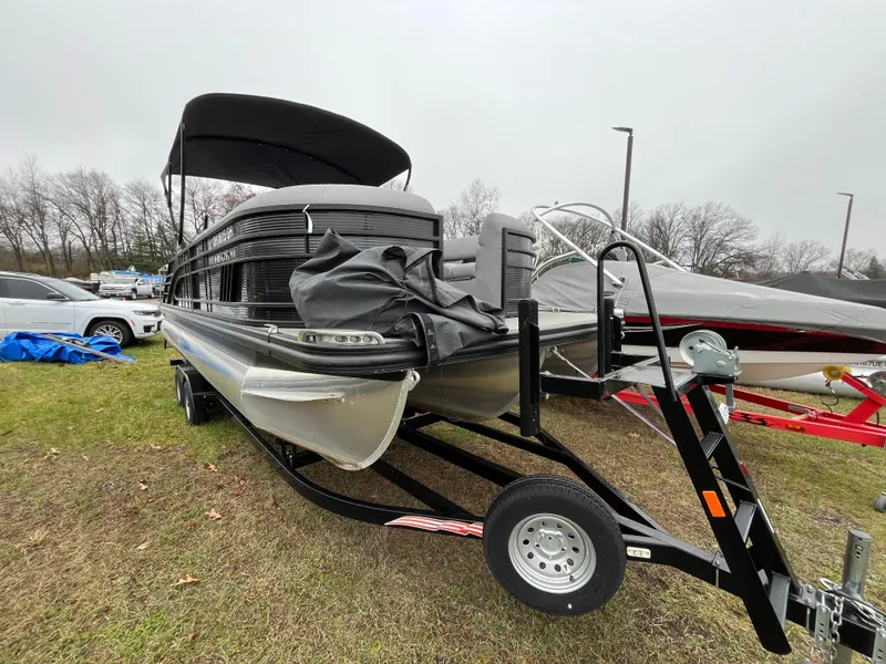 Slide: The Image of 2022 Bennington LXS SPORT 24 LXSB pontoon boat on trailer, parked outdoors. - 5