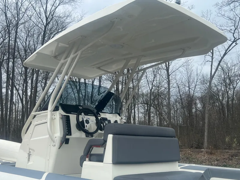 Slide: The Image of 2022 Brig Eagle 8 boat with canopy, steering console, and seating, set against a wooded background. - 17