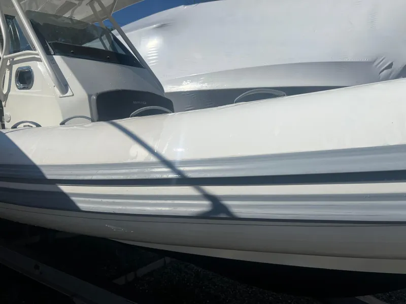 Slide: The Image of 2022 Brig Eagle 8 boat, white exterior, docked under sunlight. - 18