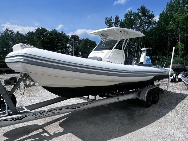 Slide: The Image of 2022 Brig Eagle 8 boat on trailer, parked outdoors under a clear blue sky. - 22