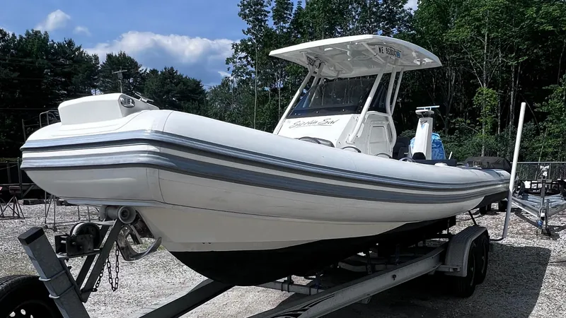 Slide: The Image of 2022 Brig Eagle 8 boat on trailer, parked outdoors with trees in background. - 23