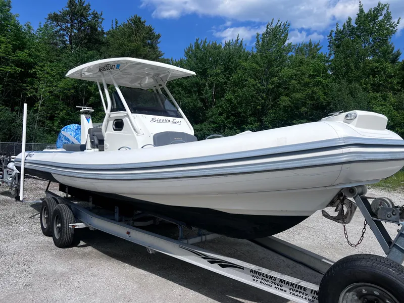 Slide: The Image of 2022 Brig Eagle 8 boat on trailer, surrounded by trees and blue sky. - 25