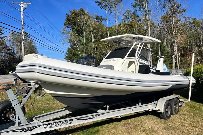 Slide: The Image of 2022 Brig Eagle 8 boat on trailer, parked outdoors with trees in the background. - 28