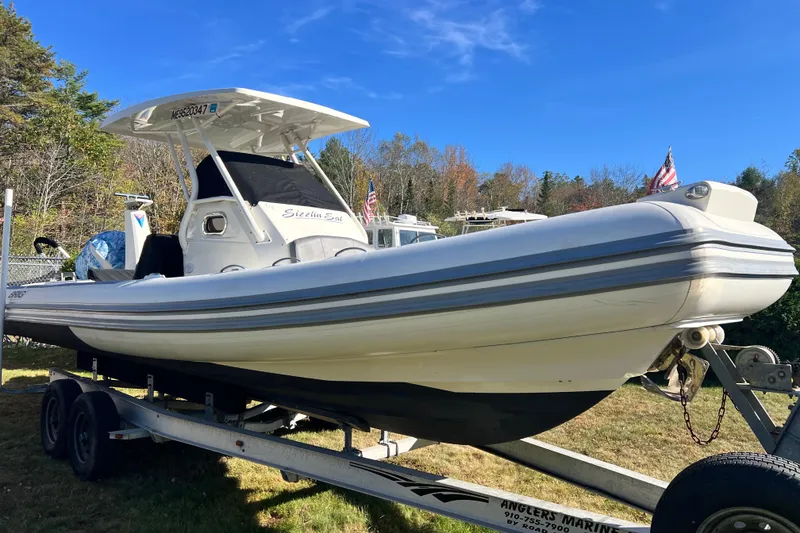 Slide: The Image of 2022 Brig Eagle 8 boat on trailer, displayed outdoors under clear blue sky. - 35