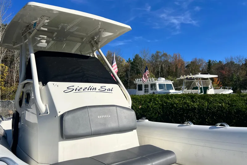 Slide: The Image of 2022 Brig Eagle 8 boat named "Sizzlin Sal" docked with American flags in the background. - 36