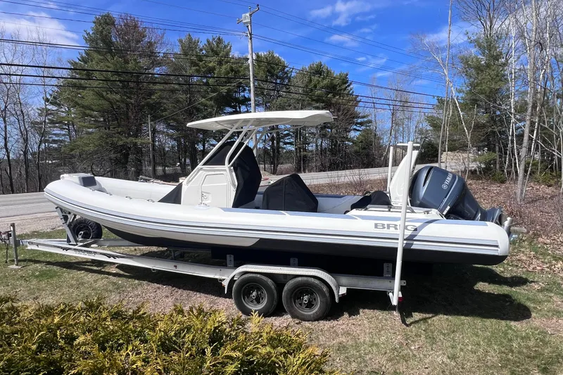 Slide: The Image of 2022 Brig Eagle 8 boat on trailer, parked outdoors with trees in background. - 43