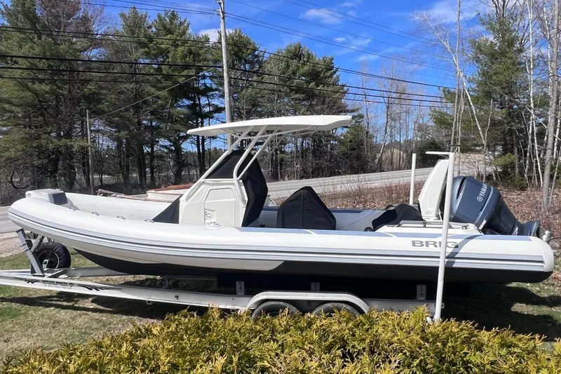 Slide: The Image of 2022 Brig Eagle 8 boat on trailer, parked outdoors with trees in background. - 44