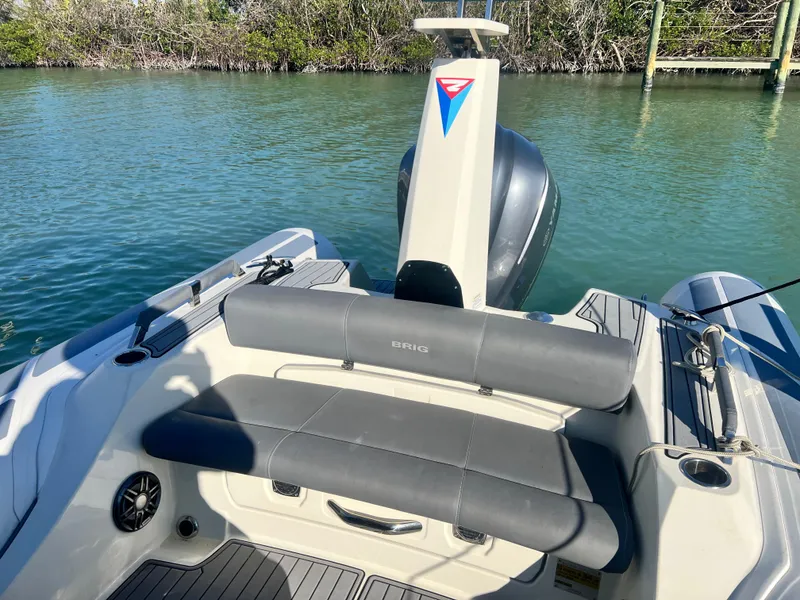 Slide: The Image of 2022 Brig Eagle 8 boat interior with seating, motor, and water backdrop. - 9