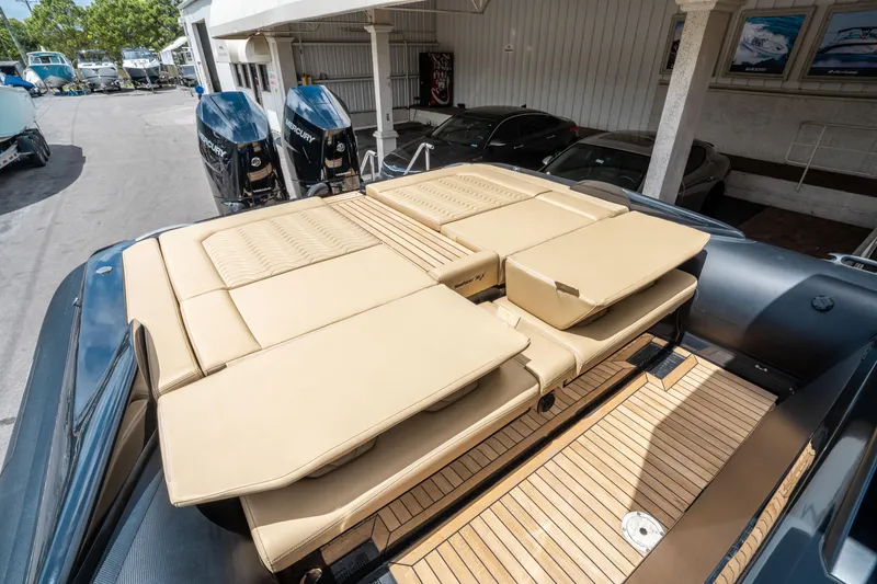 Slide: The Image of 2023 Ribco Seafarer 36 X boat with beige cushioned seating and wooden deck. - 17