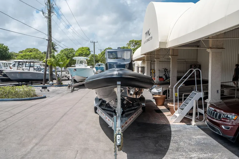 Slide: The Image of 2023 Ribco Seafarer 36 X boat on trailer at marina under cloudy sky. - 2