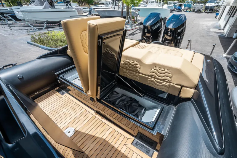Slide: The Image of 2023 Ribco Seafarer 36 X boat interior with tan seating and dual outboard engines. - 20